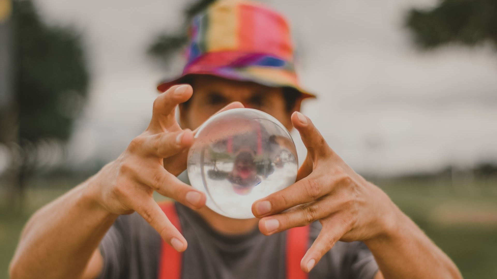 Man in colorful hat holding crystal ball